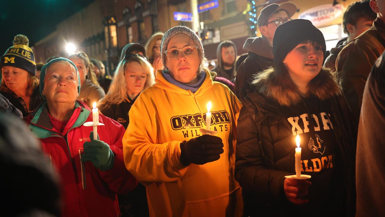 People attend a vigil downtown to honor those killed and wounded during the recent shooting at Oxford High School. Photo: Scott Olson/Getty Images/AFP