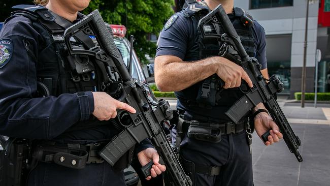 Victoria police officers hold automatic firearms.