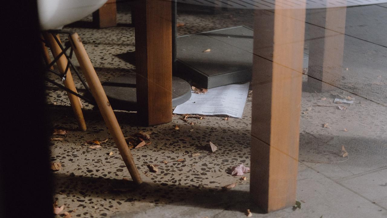 A resume under a table leg on the leaf-covered floor of a closed CBD eatery. Picture: Shaun Viljoen