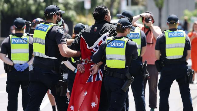 A “Free Victoria” protester is led away by police on Melbourne Cup Day in the CBD. Picture: NCA NewsWire / Ian Currie