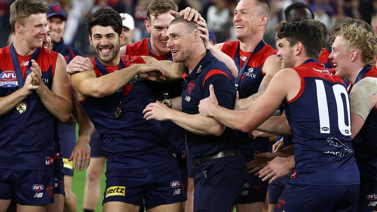 Melbourne players rally around their coach Simon Goodwin after their grand final triumph.