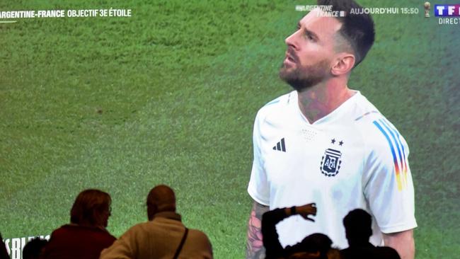 French supporters stand in front of a giant screen with Argentina's forward Lionel Messi.