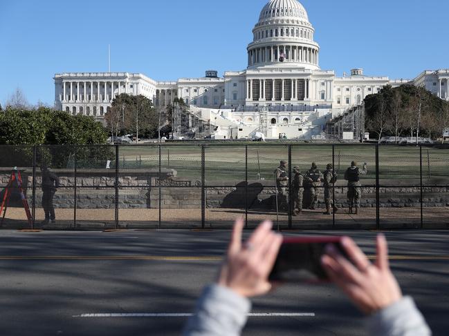 Members of the D.C. National Guard are seen outside the U.S. Capitol Building as workers construct a fence a day after a pro-Trump mob broke into the building. Picture: Getty