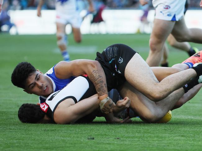 ADELAIDE, AUSTRALIA - APRIL 26: Josh Sinn of the Power is tackled by Paul Curtis of the Kangaroos during the 2025 AFL Round 07 match between the Port Adelaide Power and the North Melbourne Kangaroos at Adelaide Oval on April 26, 2025 in Adelaide, Australia. (Photo by James Elsby/AFL Photos via Getty Images)
