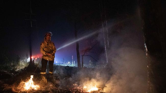 Firefighter Grant Clark from Tilba works to control a bushfire on the NSW south coast on Wednesday morning. Picture: Liam Mendes