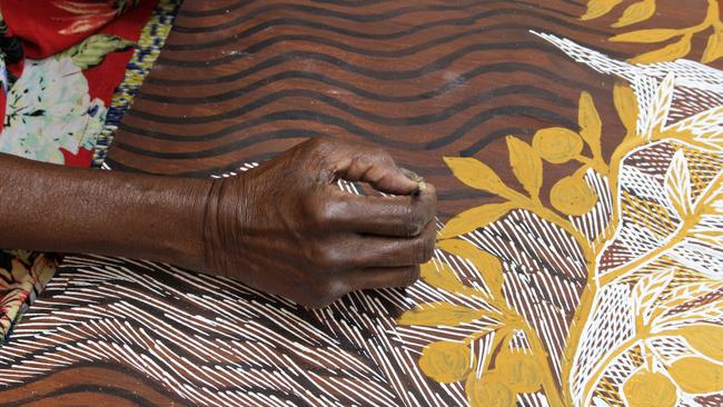 Yolngu artist Yalmakany Marawili paints a guava-like fruit called a bundjunu at the Buku-Larrnggay Mulka arts centre. Picture: Jason Walls