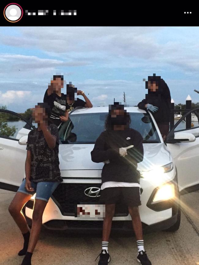 A group of young people pose in front of a stolen car in an image shared to the Townsville crime Instagram page.