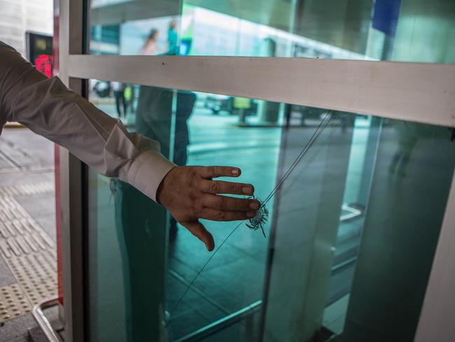 A person touches the bullet hole left on the window at the country's largest airport, Istanbul Ataturk. Picture: Getty