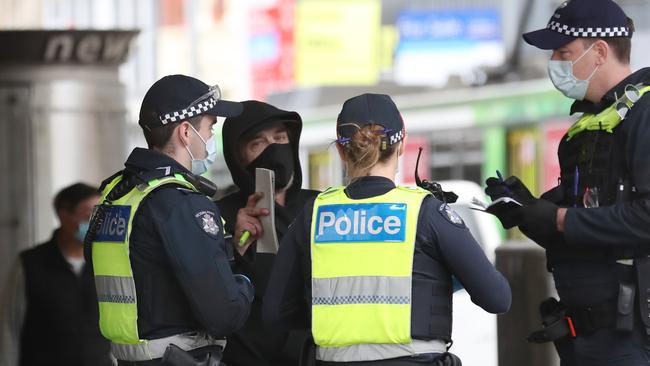 Police talk to pedestrians to ensure they are complying with chief health officer directives. Picture: David Crosling