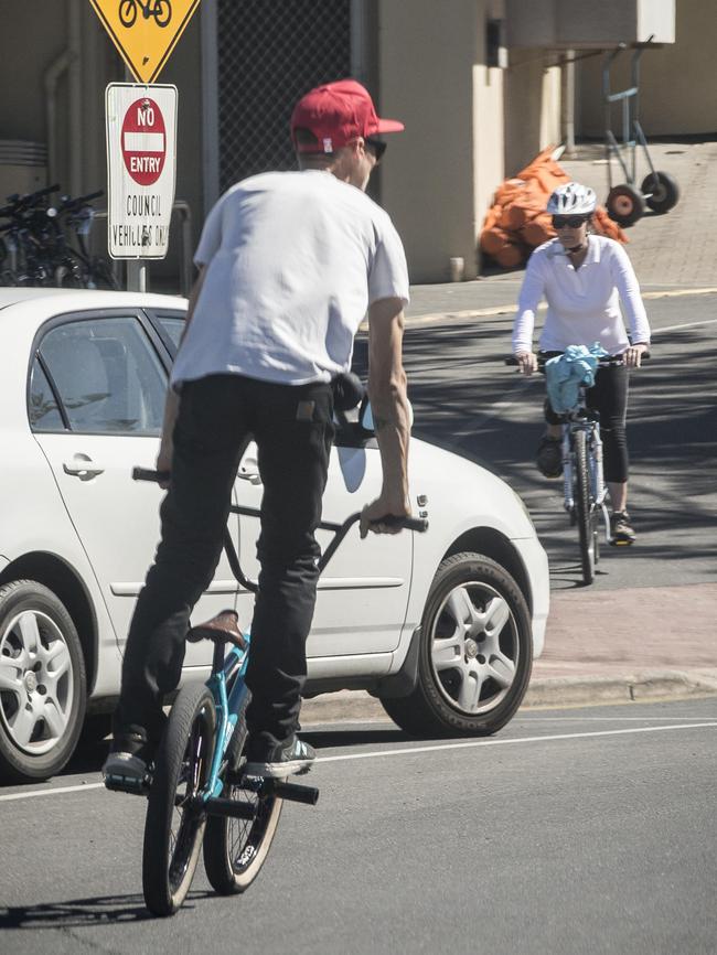 A cyclist ride on the Esplanade at Brighton without a helmet.