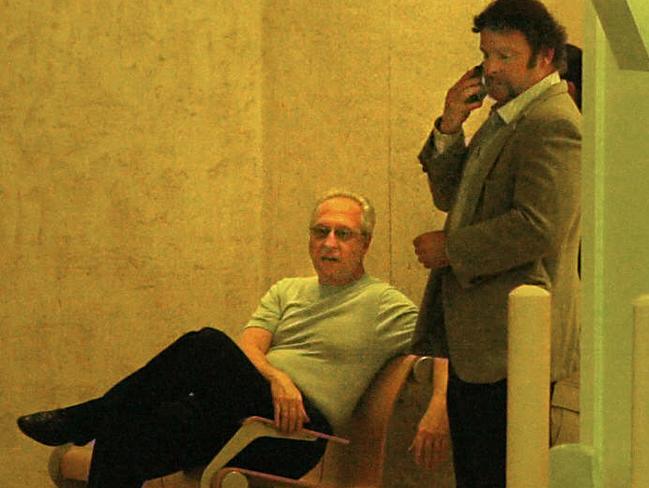 Private investigator Anthony Pellicano waits with an FBI agent to be taken into custody in the garage of his West Hollywood office in 2002.