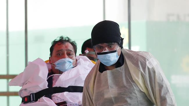 A patient is wheeled out of Elmhurst Hospital Center to a waiting ambulance yesterday in New York’s Queens borough. Picture: AP