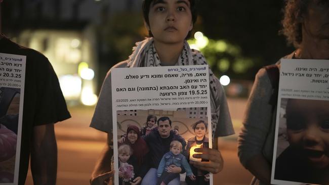 Israeli activists hold photos of Palestinian children killed during the Israel air and ground operation in the Gaza Strip, calling for an end to the war, during the protest in Tel Aviv on Saturday. AP Photo/Leo Correa