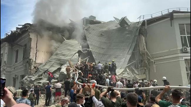 A local resident stands next to a residential building damaged as a result of a missile attack in Kyiv