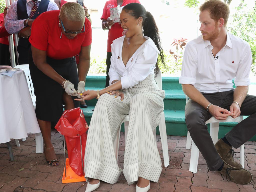 Prince Harry (R) watches as singer Rihanna (L) gets her blood sample taken for an live HIV test, in order to promote more widespread testing for the public. Picture: Getty