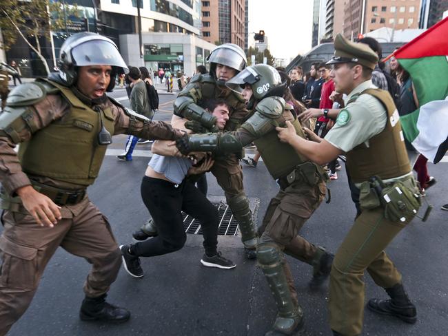 A protester is detained by riot police during an anti-war demonstration outside the US embassy in Santiago, Chile. Picture: AP Photo/Esteban Felix