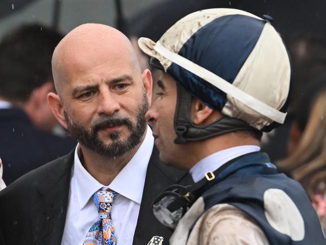 MELBOURNE, AUSTRALIA - OCTOBER 05:  Joao Moreira talks to Ozzie Kheir and other connections after riding Buckaroo to finish second in Race 8, theTab Turnbull Stakes - Betting Odds during Melbourne Racing at Flemington Racecourse on October 05, 2024 in Melbourne, Australia. (Photo by Vince Caligiuri/Getty Images)