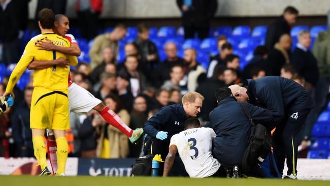 The injured Danny Rose of Spurs receives medical treatment as Asmir Begovic of Stoke City and Steven N'Zonzi of Stoke City celebrate.