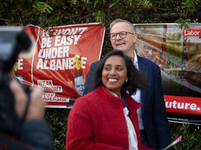 Opposition leader Anthony Albanese (back) and Labour candidate for Higgins Dr Michelle Ananda-Rajah arrive at a Polling station during election day in Carnegie, Melbourne, Australia on May 21, 2022. - Polls opened in Australia's federal election May 21, 2022 , with Prime Minister Scott Morrison fighting for another three-year term that would extend a decade of conservative rule. (Photo by Wendell Teodoro / AFP)