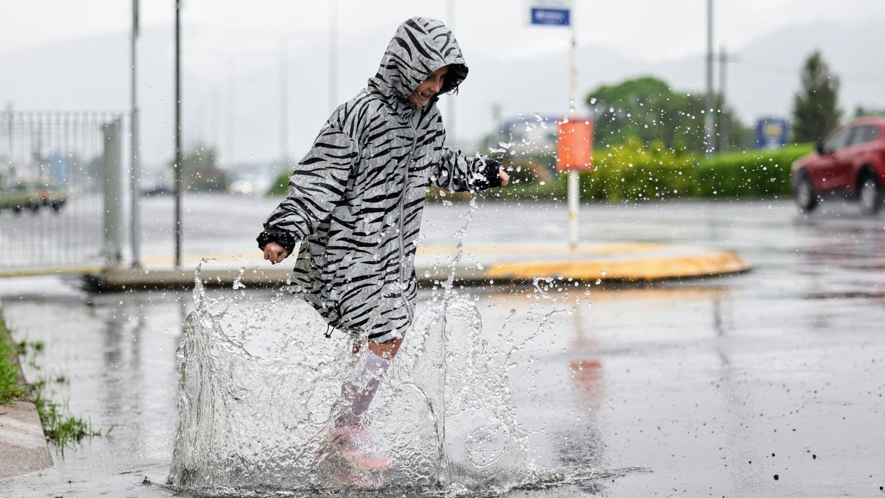 The wet season has arrived in Far North Queensland, with heavy rain falling across Cairns overnight. Pheobe Molenaar, 9, embraced the wet weather by finding some puddles to jump in when she got off the bus with her mother on Mulgrave Road. Picture: Brendan Radke