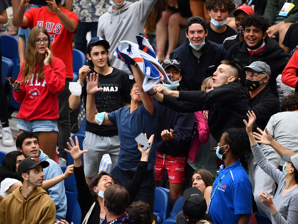 Fans in Melbourne scramble to catch Murray’s towel after the match. Picture: William West/AFP
