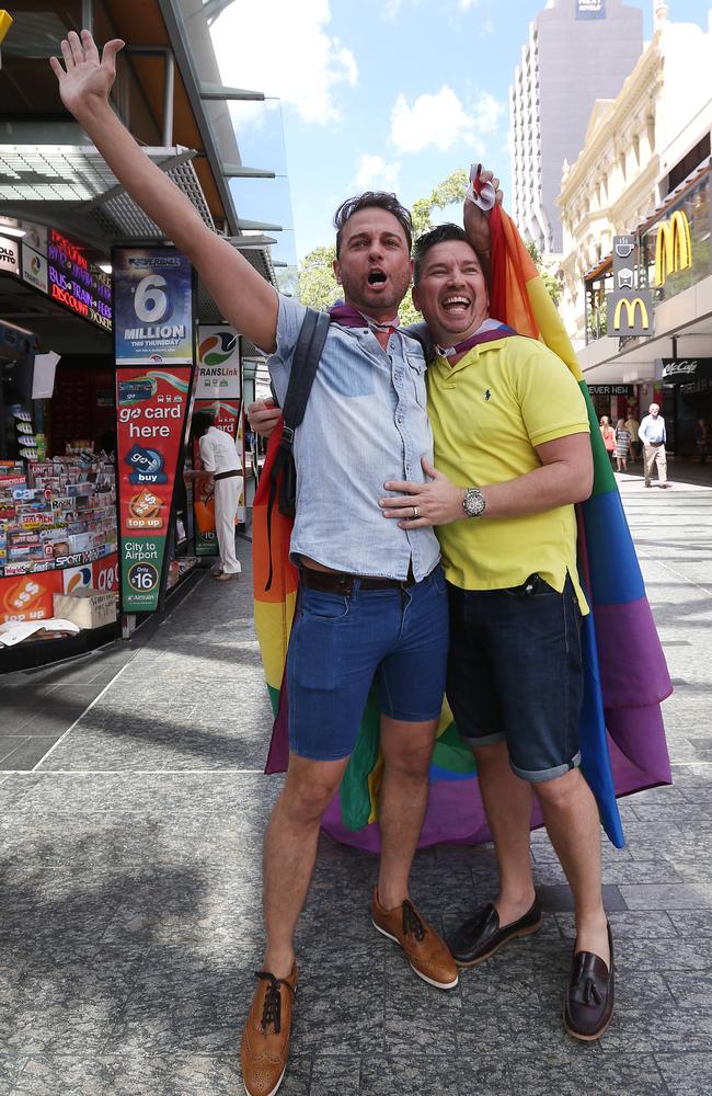 Brad Harker and partner Scott D'Amico walk through the Brisbane mall after the decision. Same-sex couples and their friends and family gather at Queens Gardens this morning to watch the SSM result announced live by the ABS. Pic Peter Wallis