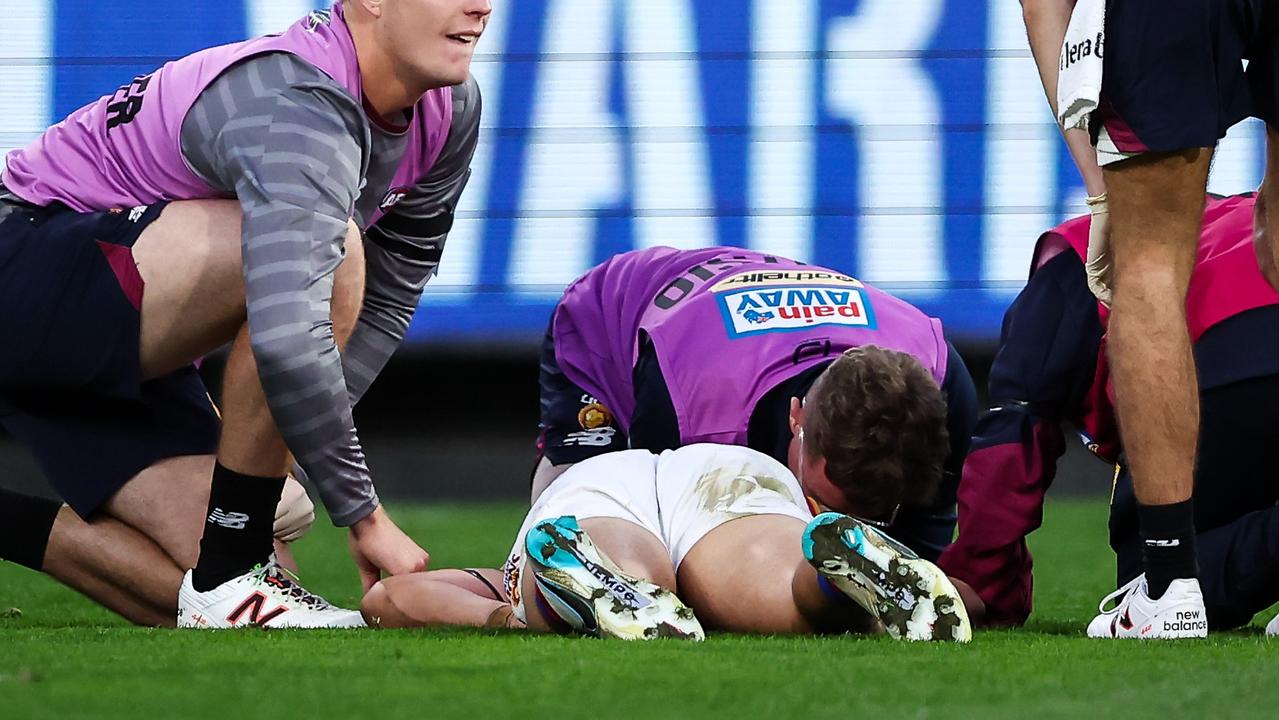 : Hugh McCluggage of the Lions lays injured at the MCG (Photo by Dylan Burns/AFL Photos via Getty Images)