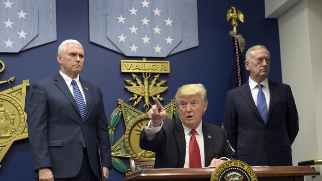 President Donald Trump gestures after signing two executive actions at the Pentagon, as Vice-President Mike Pence, left, and Defence Secretary James Mattis look on. Picture: AP