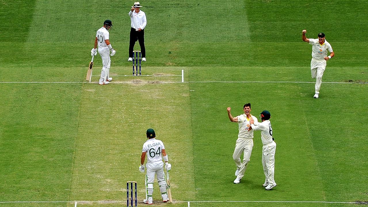 Pat Cummins of Australia celebrates with teammates after taking the wicket of Dean Elgar of South Africa. Picture: Bradley Kanaris