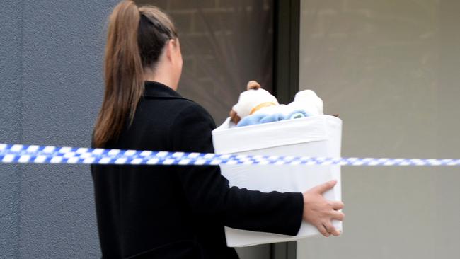 Police remove a box of children’s toys. Picture: Andrew Henshaw