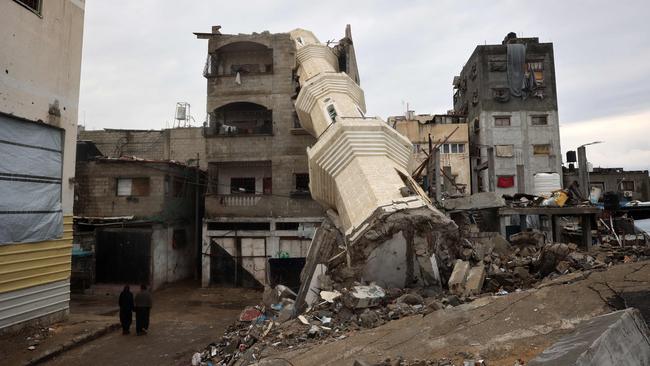 Palestinian women walk near a fallen minaret of a destroyed mosque during the Muslim holy fasting month of Ramadan, in the Nuseirat refugee camp in the central Gaza Strip.