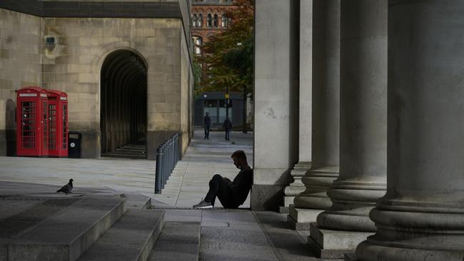 A man wears a face mask as he sits outside the Central Library in Manchester. Picture: Getty Images