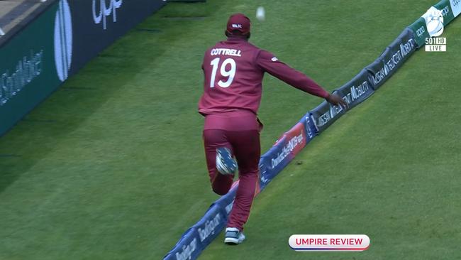 West Indies' Sheldon Cottrell launches the ball back in the air as he crosses the boundary rope..