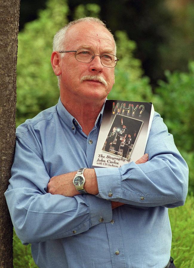 Peter Norman with the biography of American runner John Carlos, the American athlete who placed third behind him in the 1968 Mexico City Games.