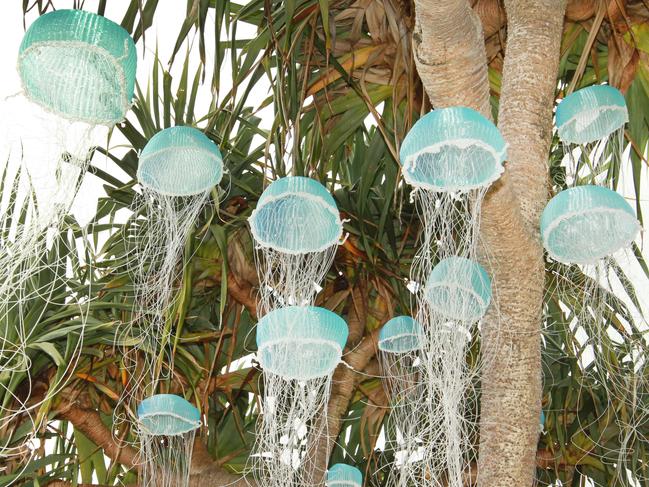 Crowds and People looking at art at the Swell sculpture festival held on Currumbin Beach . at art by Melissa Hirsch called Jellyfish Tree . Picture Mike Batterham
