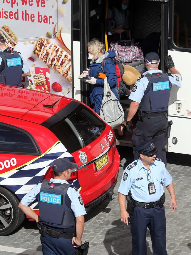 Police escort travellers off a bus and into the Rydges Hotel. Picture: Matrix