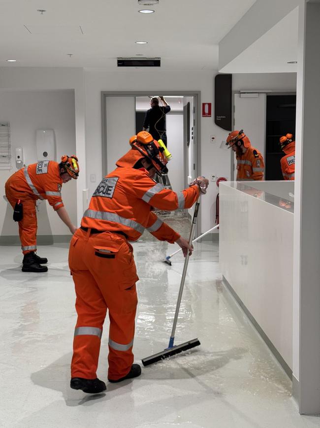 Workers clean up the flooding in the Bragg Centre. Picture: Chris Picton