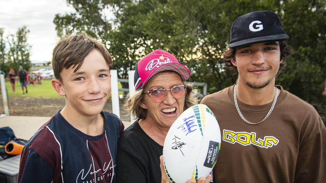 Kerri Fedrick shows off her signed football with nephews Brock Taylor (left) and Jake Taylor.