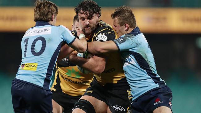 Jeremy Thrush of the Force takes on two Tahs players at Sydney Cricket Ground earlier this month.