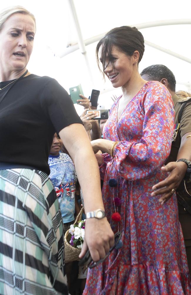 Stressed-looking security guards lead Meghan out of the marketplace. Photo: Ian Vogler - Pool/Getty Images
