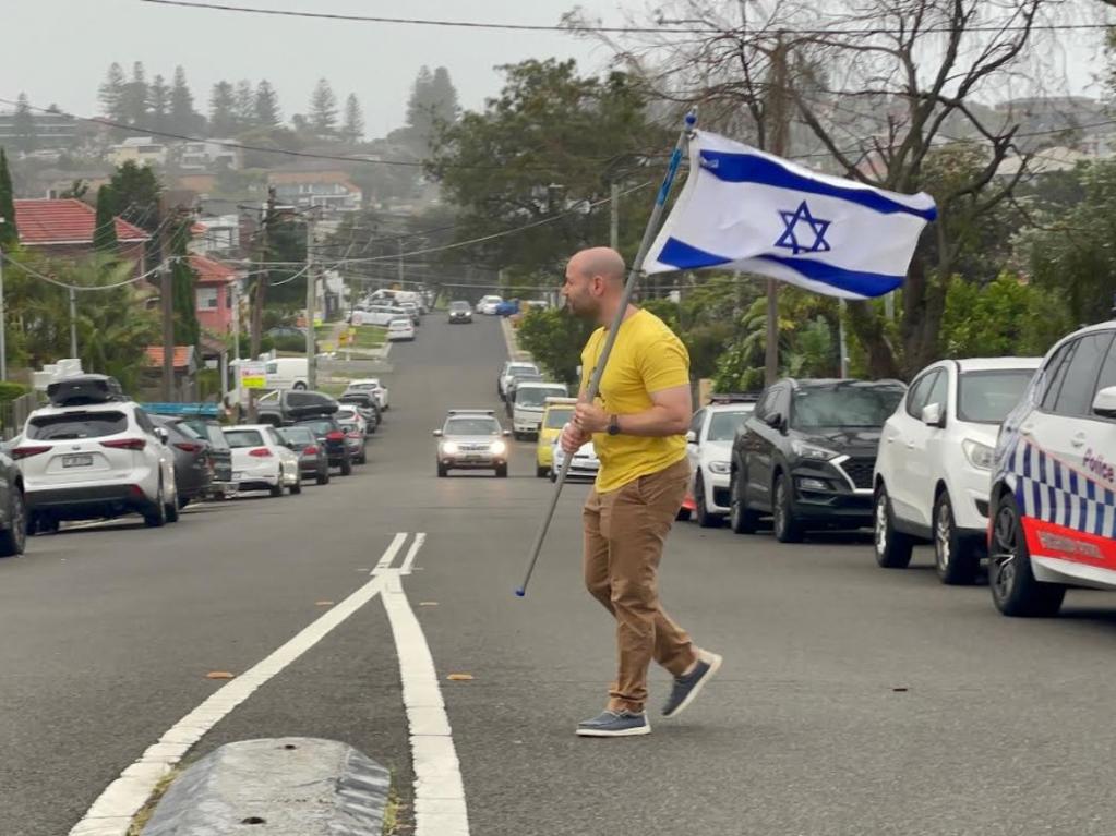 A man arrived at the scene on Friday morning holding the Israeli flag. Picture: Madeline Crittenden