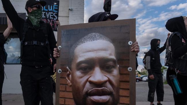 Protestors hold a picture of George Floyd, who died in Minneapolis while a white officer held his knee on his neck for several minutes. Picture: Seth Herald/AFP