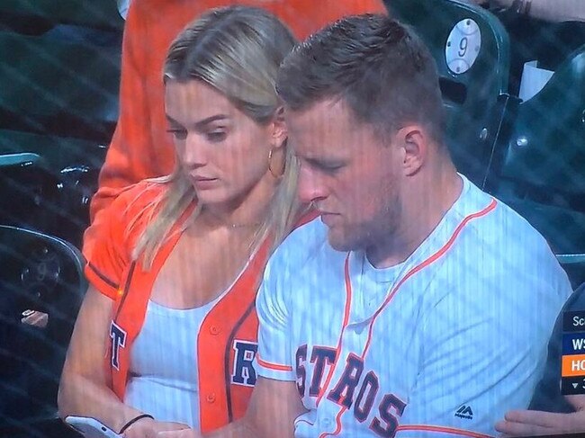 Kealia Ohai and JJ Watt take in the game ... or the contents of his phone.