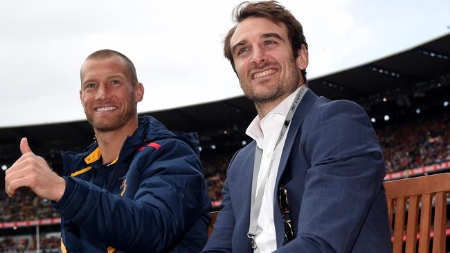 Jobe Watson does a lap of honour of the MCG with fellow retiree, Crow Scott Thompson. Picture: Nicole Garmston