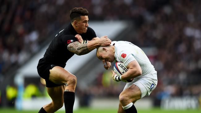 Mike Brown of England is tackled by Sonny Bill Williams of New Zealand.