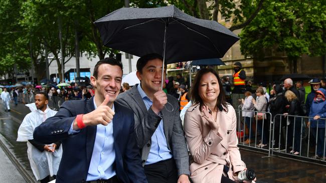 Jockey Jordan Childs, left, braves the weather during the parade. Picture: Vince Caligiuri/AAP