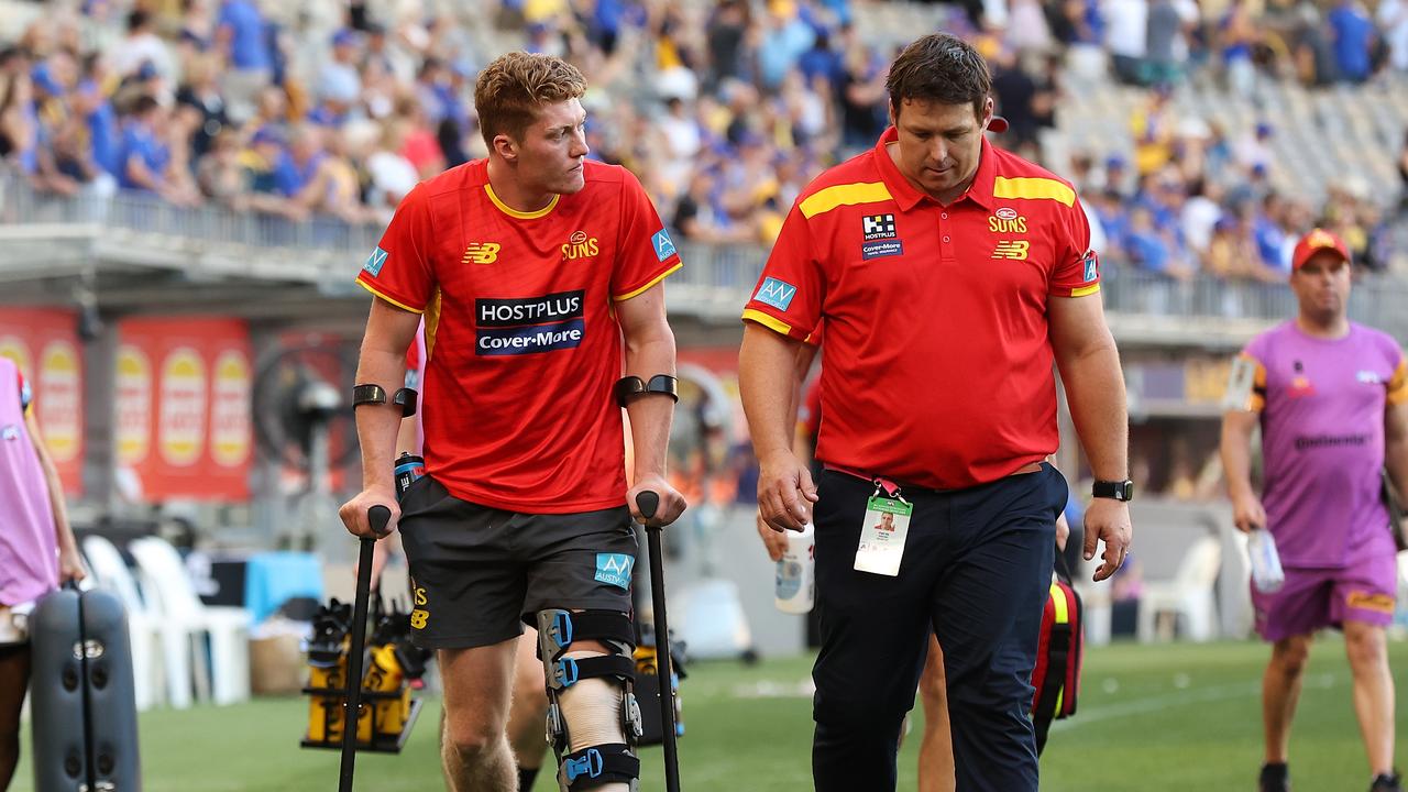 Matthew Rowell walks the sidelines on crutches with coach Stuart Dew.