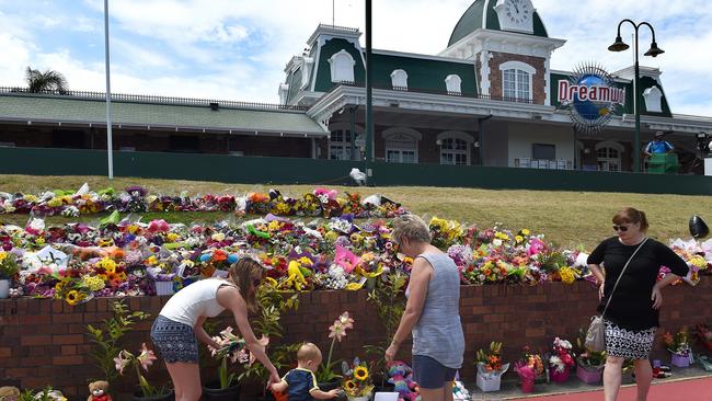 Floral tributes are laid outside the Dreamworld Theme Park on the Gold Coast — a support fund for the affected families has climbed through $400,000. (AAP Image/Dave Hunt) NO ARCHIVING