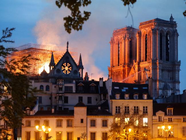 Firefighter douse flames billowing from the roof at Notre-Dame Cathedral in Paris on April 15, 2019. - A major fire broke out at the landmark Notre-Dame Cathedral in central Paris sending flames and huge clouds of grey smoke billowing into the sky, the fire service said. The flames and smoke plumed from the spire and roof of the gothic cathedral, visited by millions of people a year, where renovations are currently underway. (Photo by FRANCOIS GUILLOT / AFP)