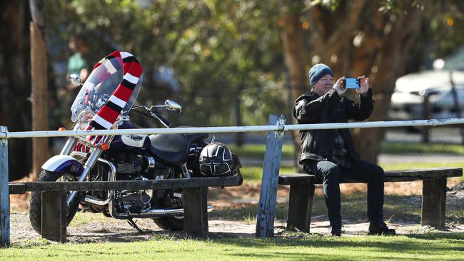 A Saints fan laps up St Kilda training in Noosa from a socially distant boundary.